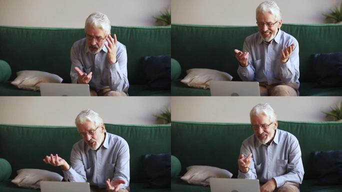 老人正在使用网络摄像头看着笔记本电脑，使视频成为焦点