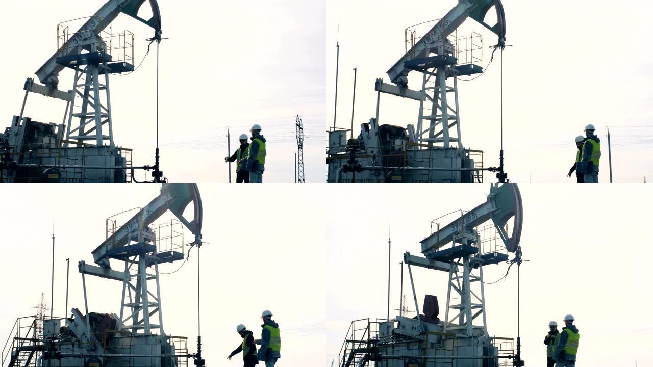 检查石油井架工作的人。石油生产行业概念。