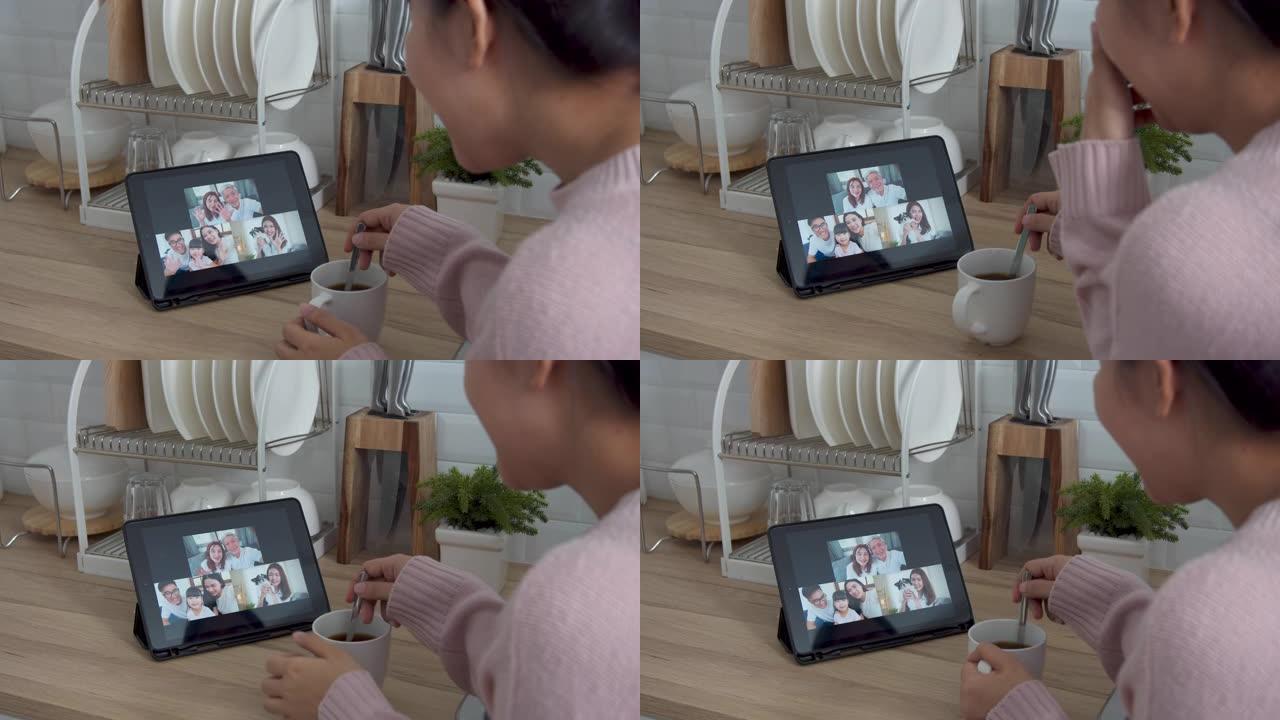 亚洲妇女在家工作时，在家厨房里通过视频通话网络摄像头与家人交谈。自我隔离，社交距离，检疫保护冠状病毒