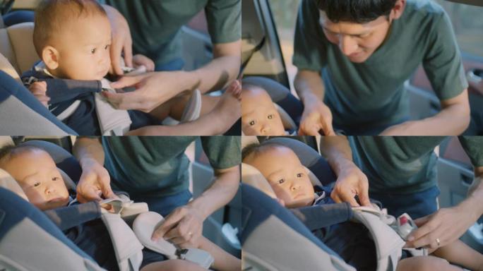 亚洲父亲将儿子放在汽车座椅上的特写镜头，慢动作