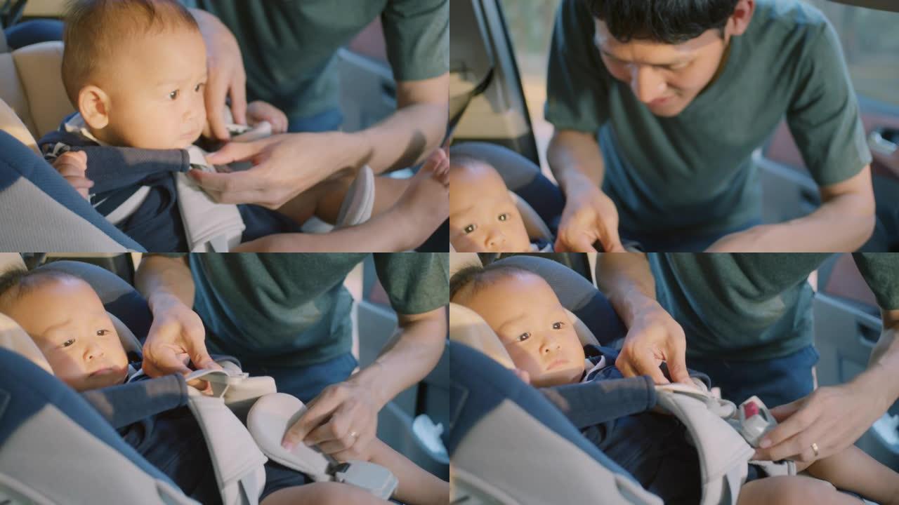 亚洲父亲将儿子放在汽车座椅上的特写镜头，慢动作