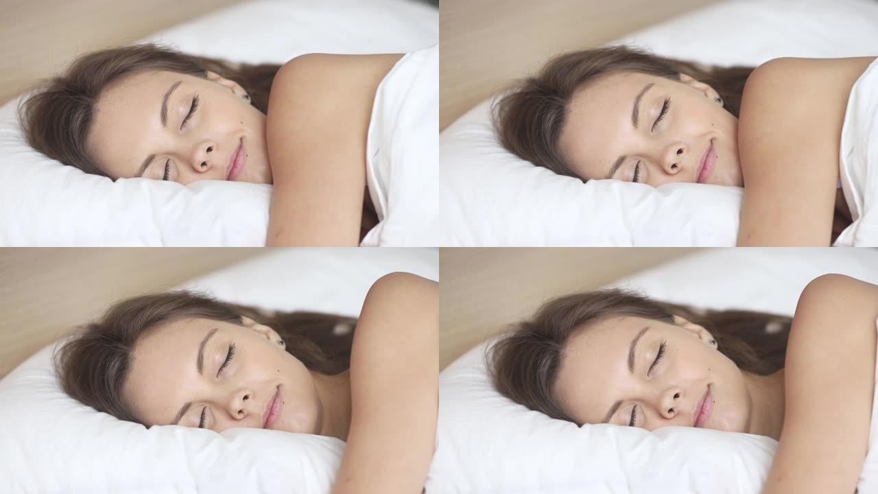 平静的女人在柔软的枕头上舒适的床上睡得很好