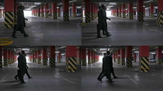 穿西装的男人在地下停车场散步