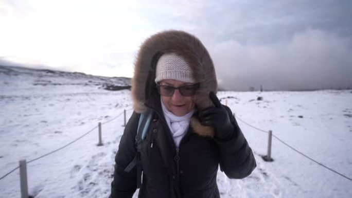 在冰岛的寒风中行走的高级妇女