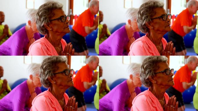 活跃的混血老年人在健身室4k表演瑜伽的侧视图