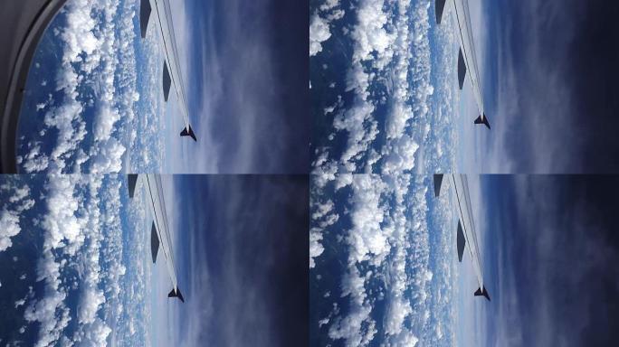 让我们旅行吧。多莉放大飞机机翼在云上飞行的飞机窗口的镜头