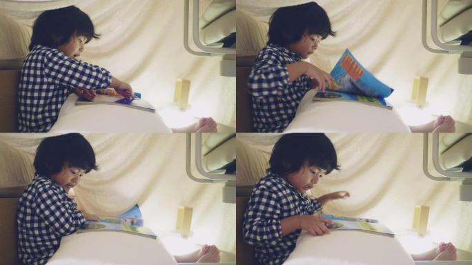 亚洲男孩在家庭帐篷里读童话。