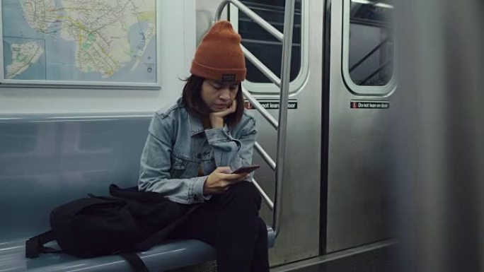 在公共交通中使用智能手机的年轻美女