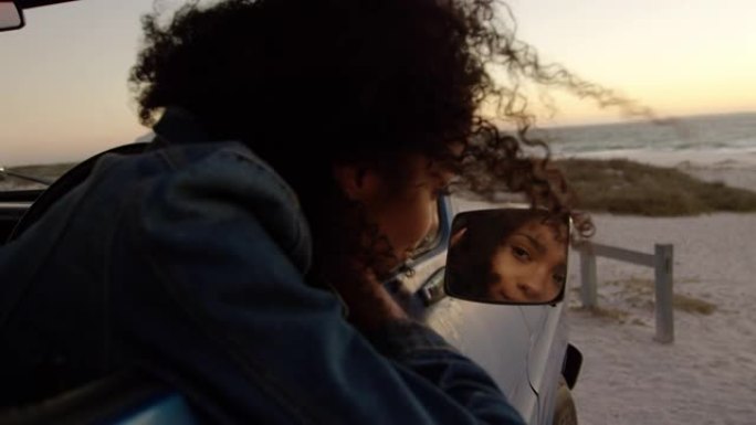 女人在4k海滩上看着皮卡车的后视镜