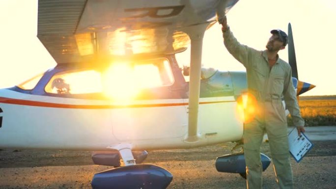 男性飞行员在日落期间清洁飞机