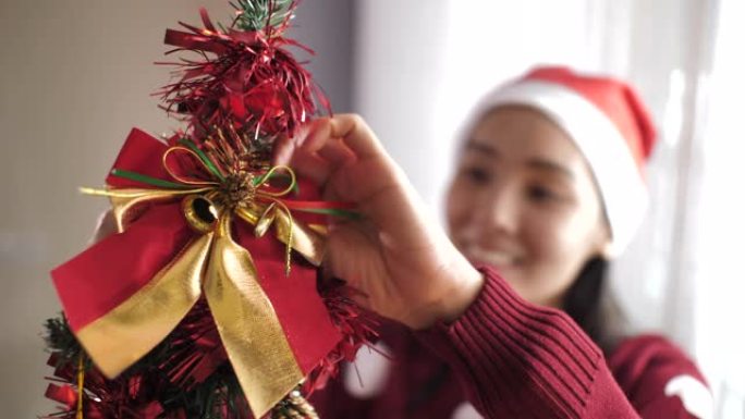 女人用球形装饰品装饰圣诞树