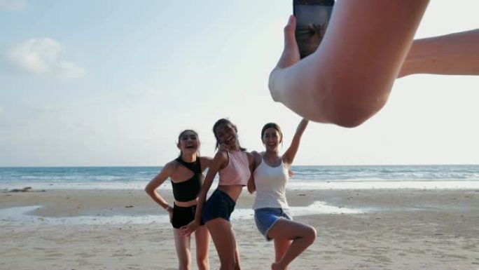 群友在海滩用手机自拍，快乐的朋友自拍，在海滩上玩得开心。假期-iStock