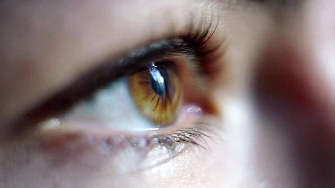 年轻女性棕色眼睛在慢动作中闪烁的特写微距镜头。