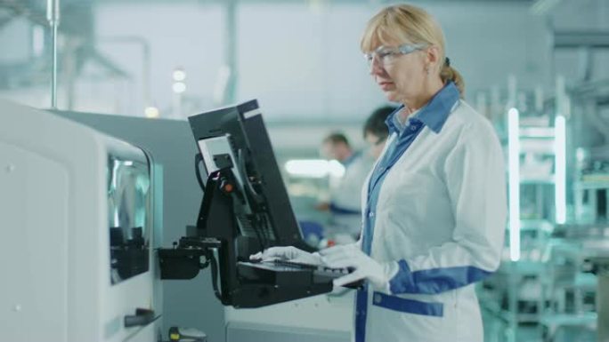 在高科技工厂，女工程师使用绿屏计算机对印刷电路板表面安装装配线的拾取和放置电子机械进行编程。