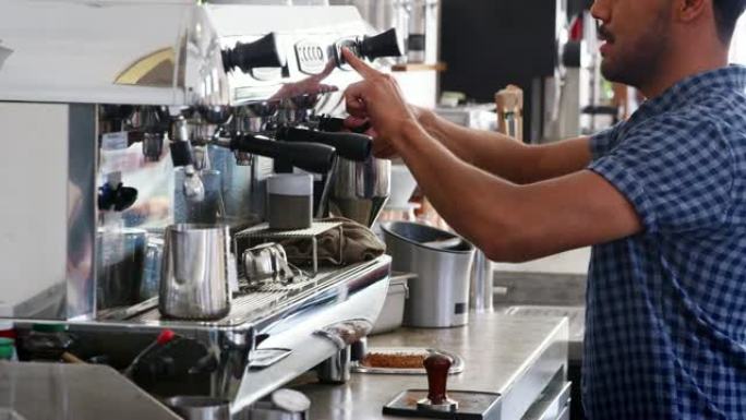 年轻的男咖啡师在咖啡店准备浓缩咖啡