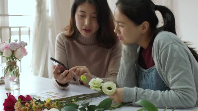 花店正在使用智能手机向她的学生展示花卉信息