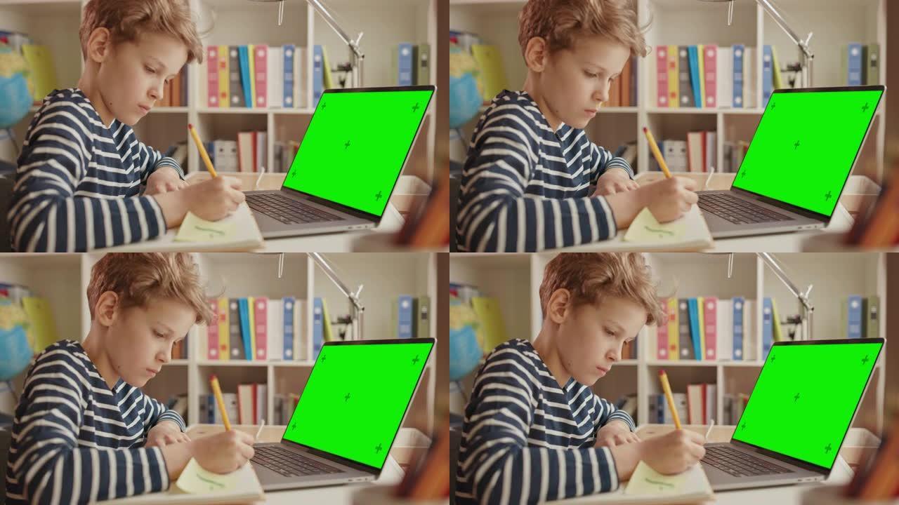 聪明的小男孩使用绿屏笔记本电脑进行学习，写下有用的信息。远程学习、电子教育、电子学习理念