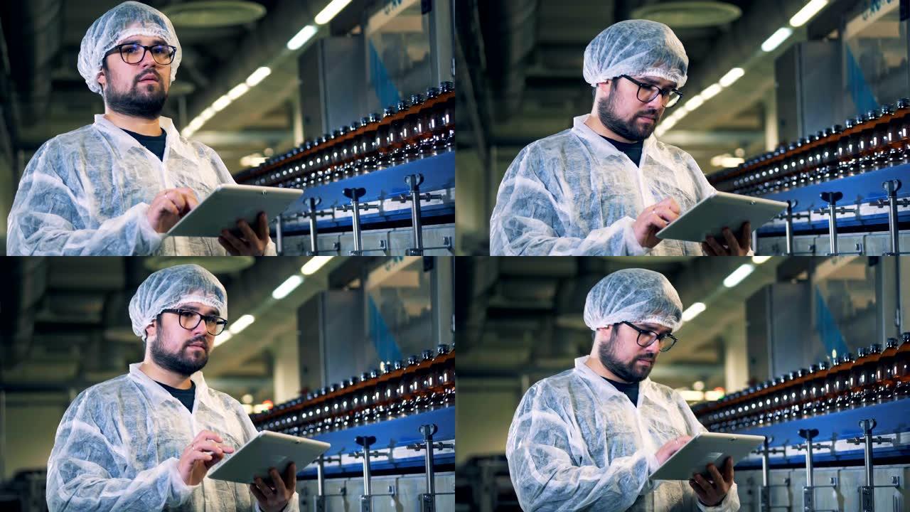 戴眼镜的男性酿酒厂专家正站着用电脑工作