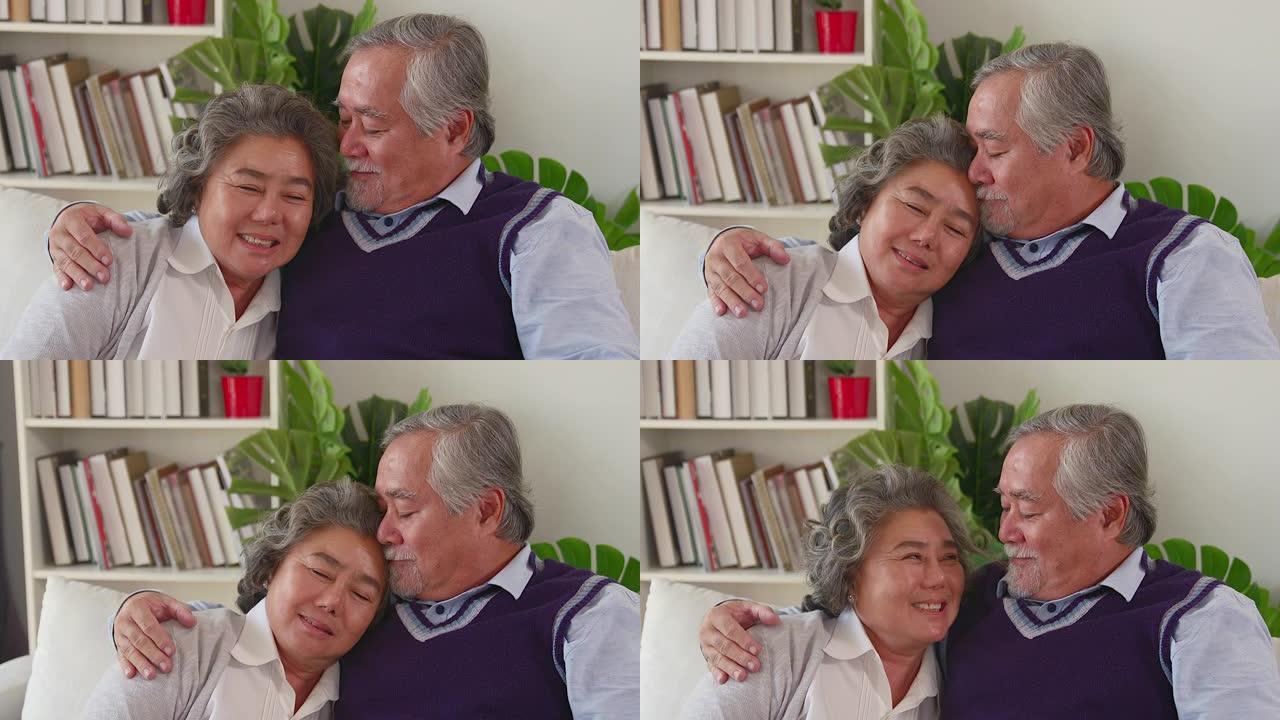 年迈的丈夫坐着，用从妻子背上取出的温暖包裹着妻子的肩膀，看到丈夫的脸上充满了幸福的爱退休了仍然相爱的
