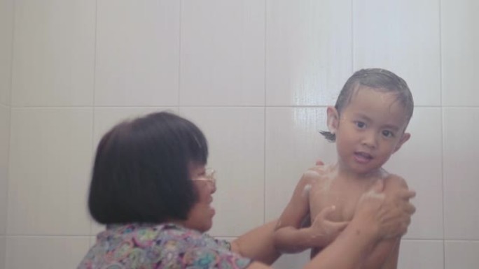 祖母在浴室给她的孙子洗澡。