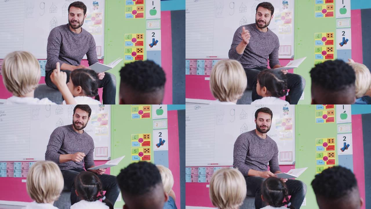 男老师在教室里读故事时，小学生举手回答问题