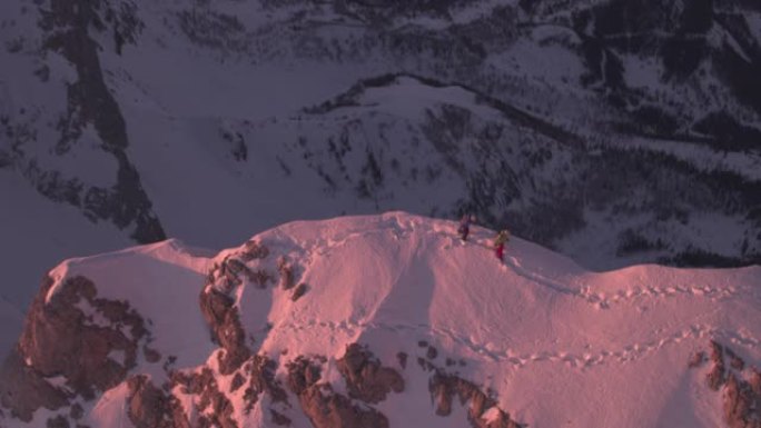 在积雪覆盖的山脊上行走的男性登山者