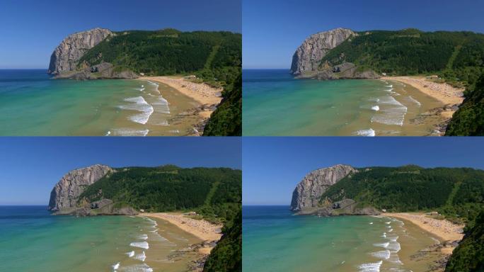 西班牙拉加海滩。泡沫状的碧绿海水在沙质海岸上滚动。人们在拥挤的海滩上放松身心，在海洋中游泳。UHD