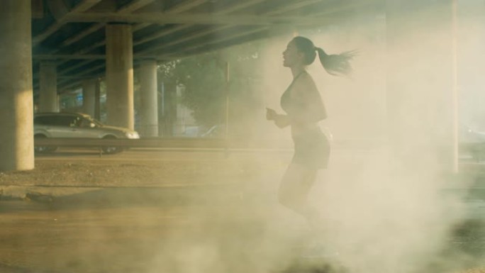 一个穿着黑色运动上衣和短裤的美丽健身女孩在烟雾弥漫的街道上慢跑的慢动作镜头。她在城市环境中奔跑，背景