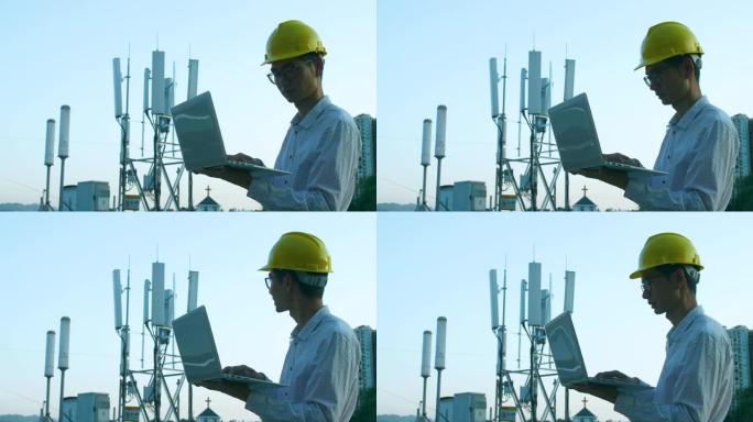 工程师使用笔记本电脑检查5g电信基站塔
