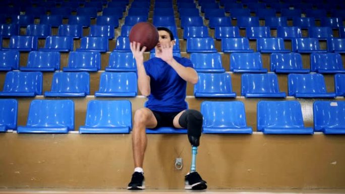 一名假腿的男性坐着玩篮球