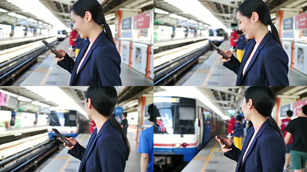 在地铁站上使用智能手机的女商人