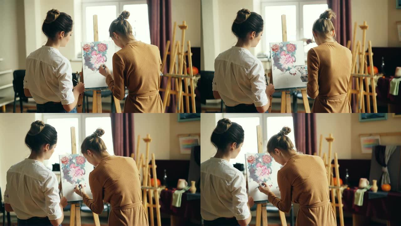 艺术系学生在画布上画花的背景图和她乐于助人的老师站在附近检查她的作品。视觉艺术与教育理念。