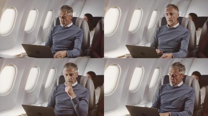 成熟的商人在公司飞机上使用笔记本电脑