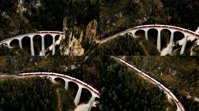 在史诗般的夏季瑞士阿尔卑斯山著名的历史悠久的Landwasser高架桥上，无人驾驶飞机飞越冰川快车。