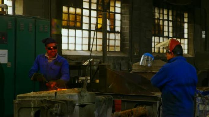 在4k车间的炉中混合模制金属的男工人