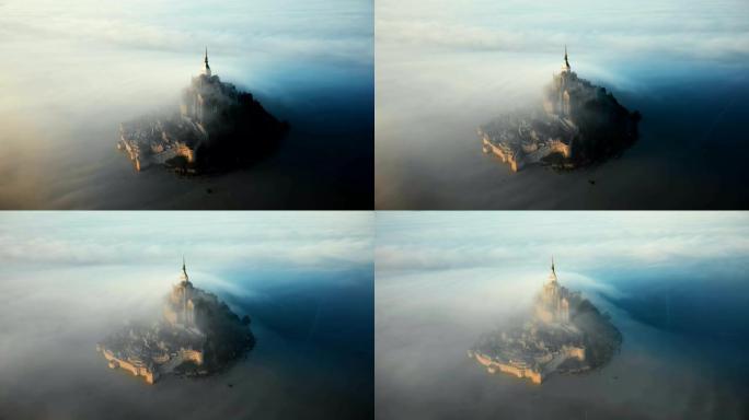 诺曼底空灵山圣米歇尔岛城堡覆盖着惊人的日出雾云的史诗航拍。