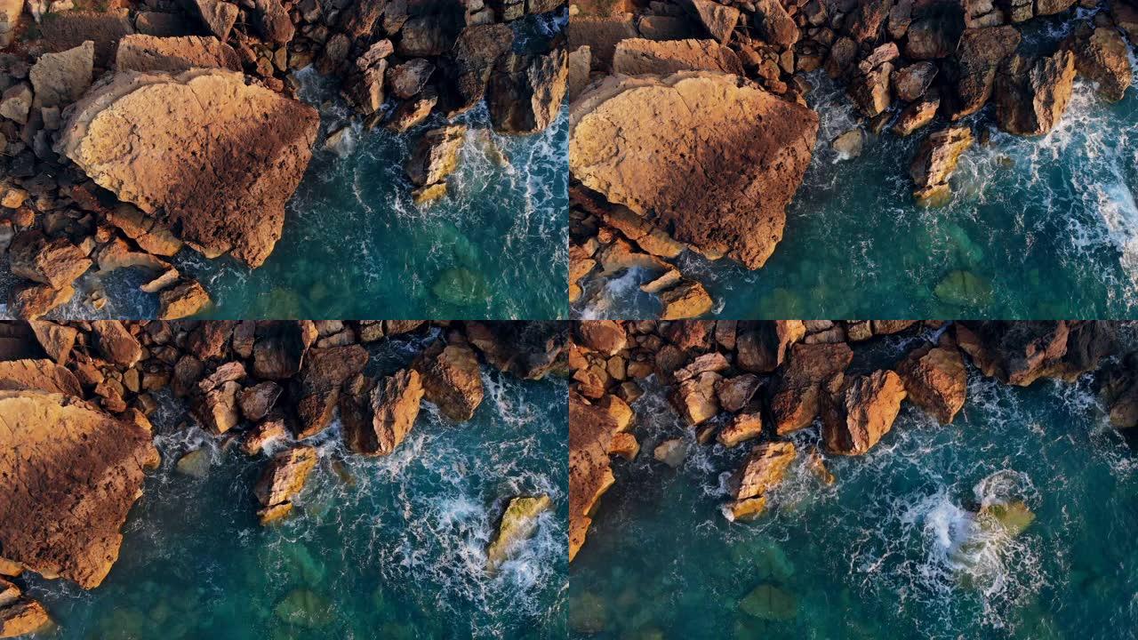 蓝海拍打高高的岩石的鸟瞰图。