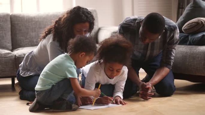 快乐的黑人妈妈爸爸和孩子们在家里画画