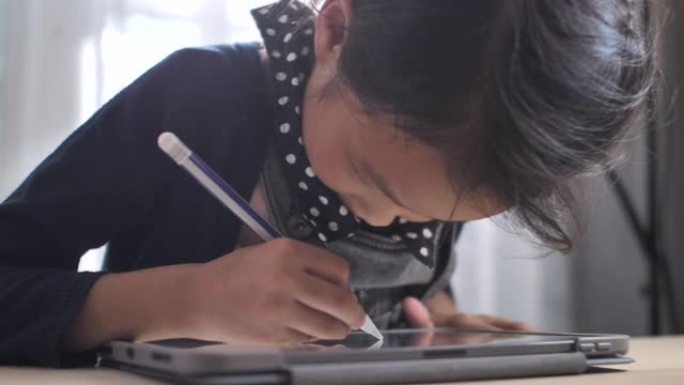 亚洲女孩在家在数字平板电脑上做作业