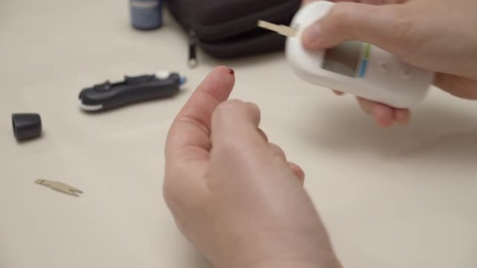 糖尿病患者刺破手指进行血糖测试