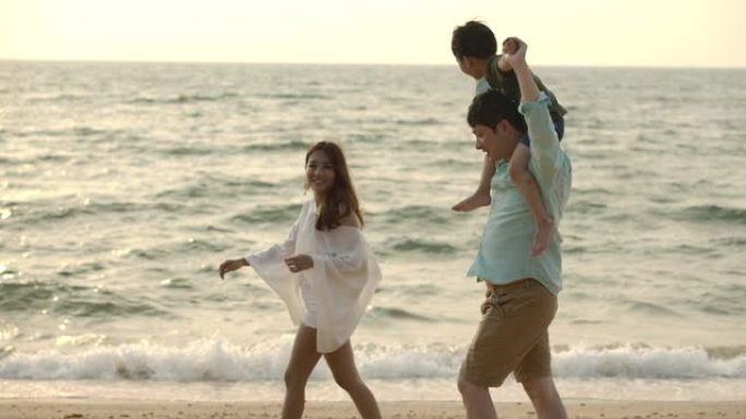 快乐的亚洲家庭在暑假享受和走在海滩上。慢动作。家庭、假期和旅行概念。
