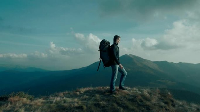 那个背着旅游背包的男人站在美丽的山上