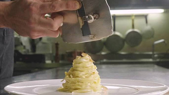 在意大利专业厨房中，厨师将胡椒慢动作倒在盘子或水中