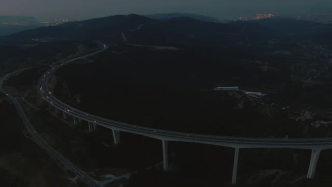 空中: 在一个有雾的秋夜，在一座巨大的公路桥上方高飞。