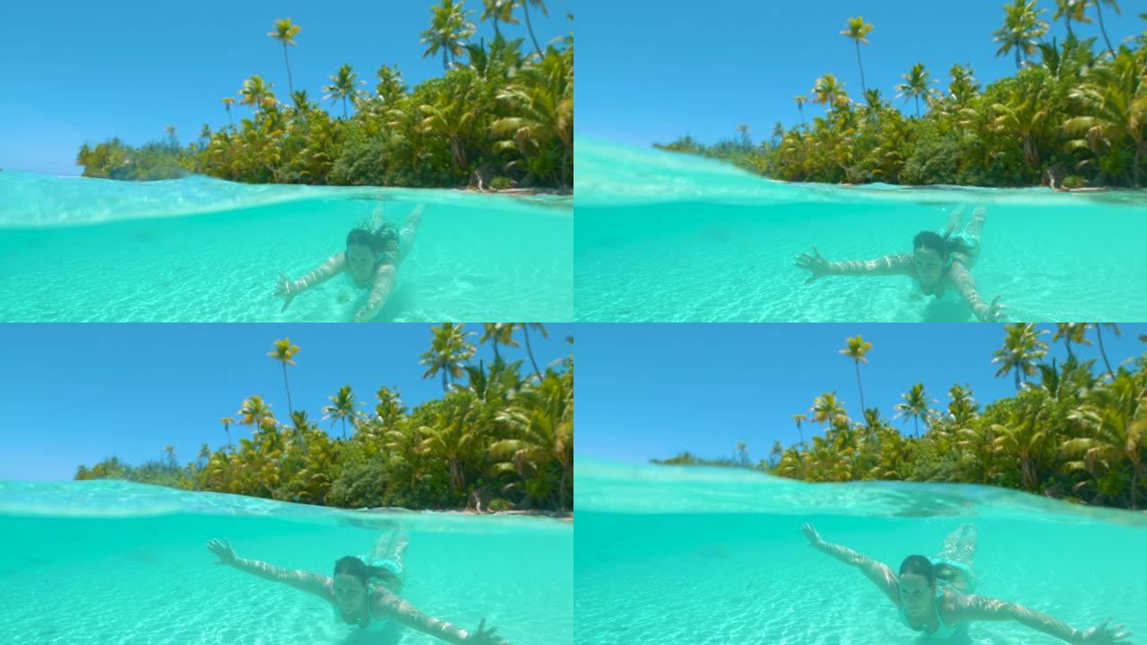 慢动作: 快乐的女人在绿松石海洋中的天堂岛潜水