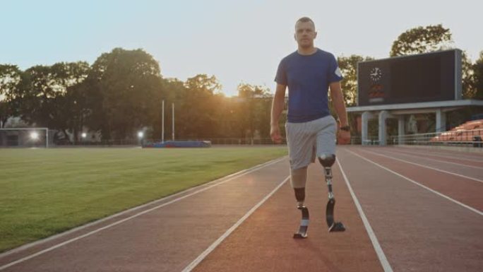 在一个阳光明媚的下午，在室外体育场进行训练时，有假肢跑步刀片的运动残疾人健身男子正在行走。截肢跑步者