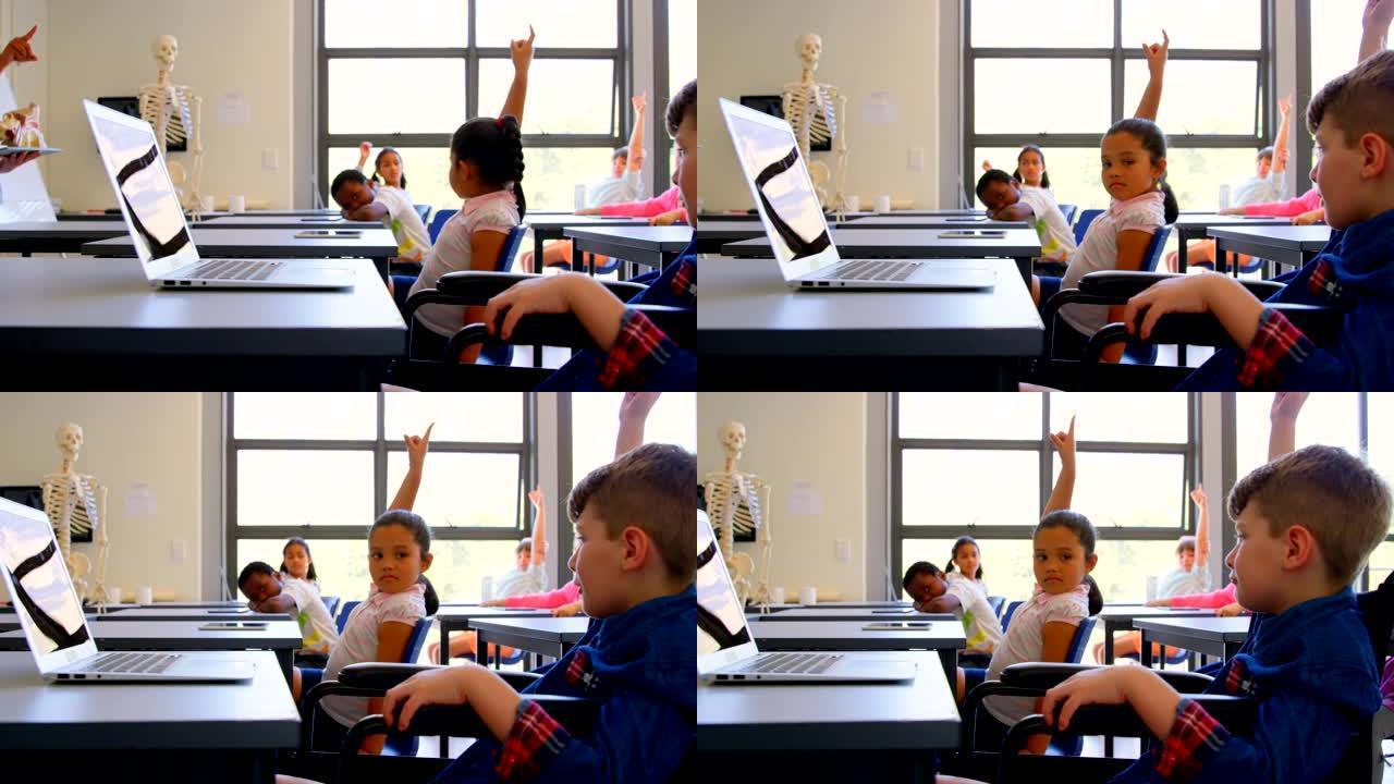 小学生坐在4k小学的书桌上举手