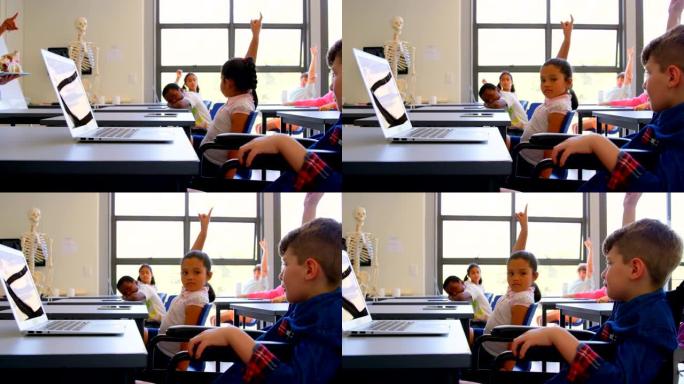 小学生坐在4k小学的书桌上举手