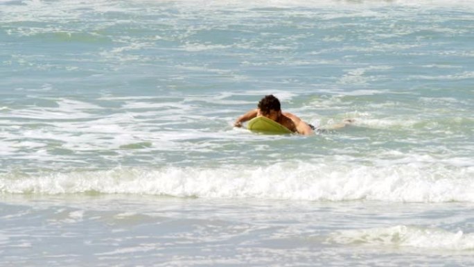 男性冲浪者在4k海滩用冲浪板在海里冲浪