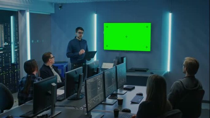 专业的IT开发人员团队开会，演讲者谈论新概念，墙上的电视上有绿色的模拟屏幕。概念: 软件开发、深度学
